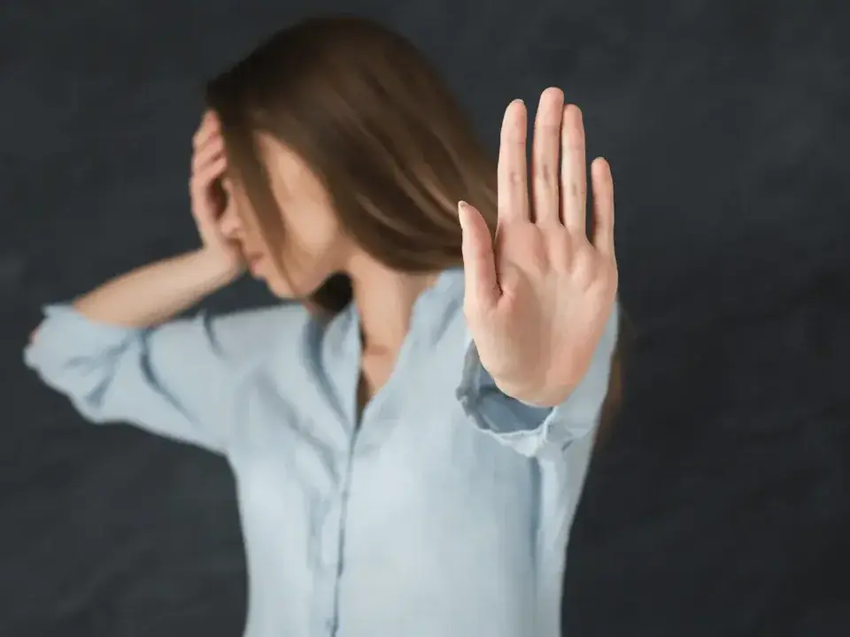 Frau hebt abwehrend die Hand